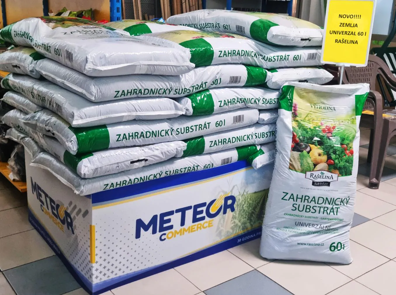 Bag of quality universal growing medium beside young vegetable and flower seedlings in a greenhouse – Rašelina, in our range